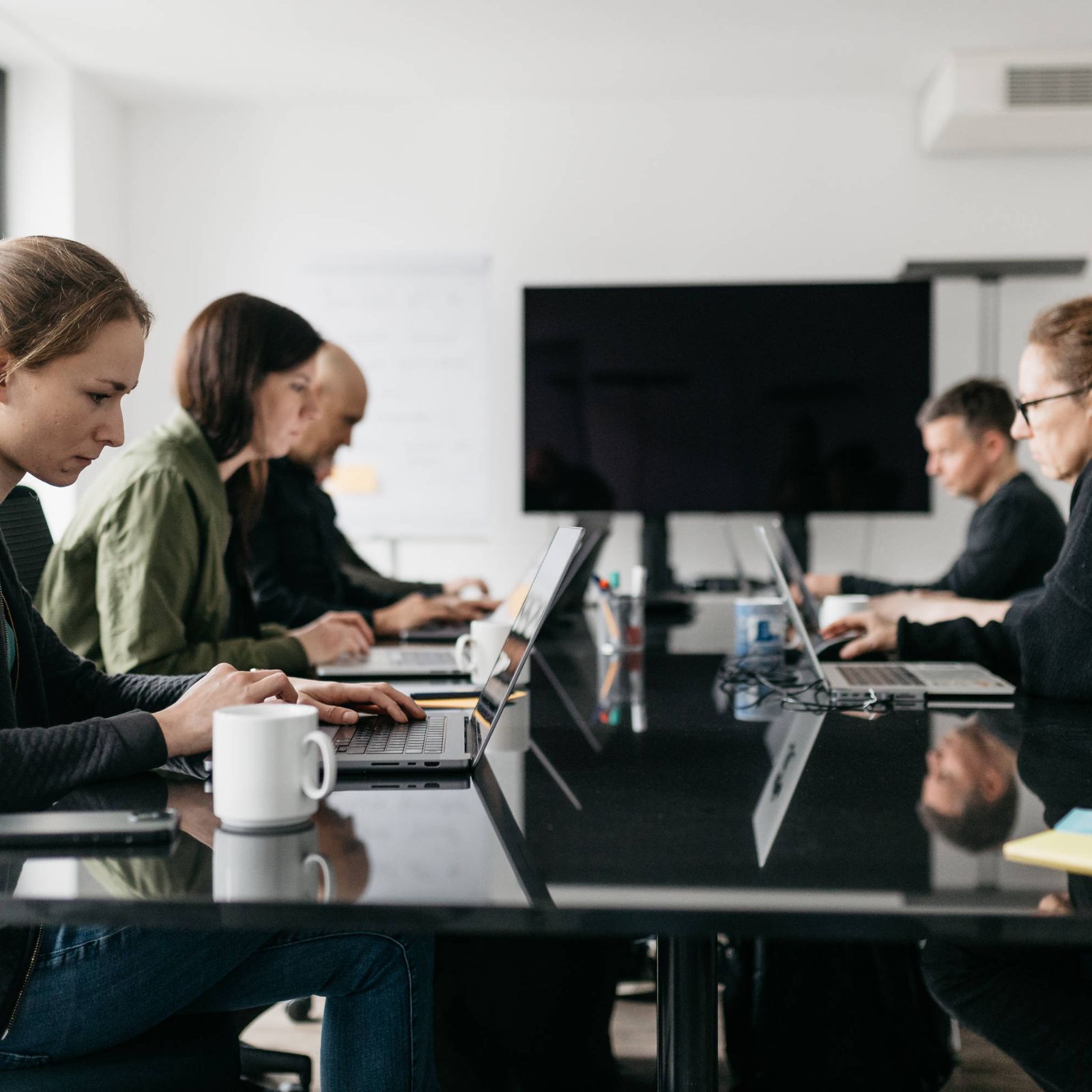 Mitarbeiter der cyber:con sitzen zusammen und analysieren Probleme bzw. tauschen sich aus. 